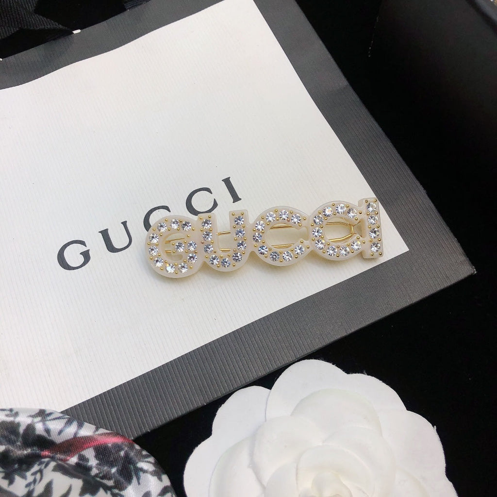 GUCCI 26S CRYSTAL EMBELLISHED SCRIPT LOGO STATEMENT BROOCH IN GOLD TONE METAL 629881