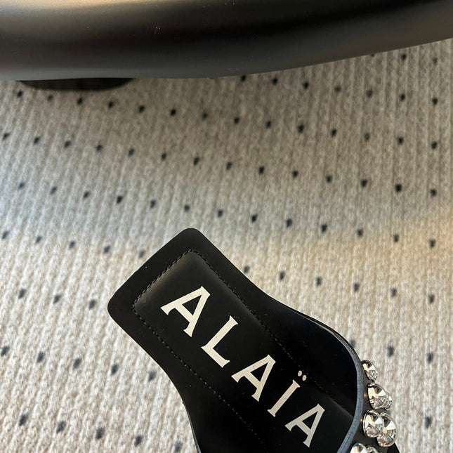ALAIA FOLDED FLAT MULES WITH SPHERES ON BLACK CALFSKIN