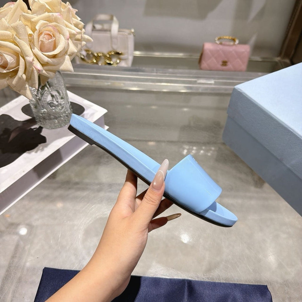 PRADA 26S LOGO EMBOSSED SLIDE SANDALS IN SKY BLUE PATENT CALFSKIN