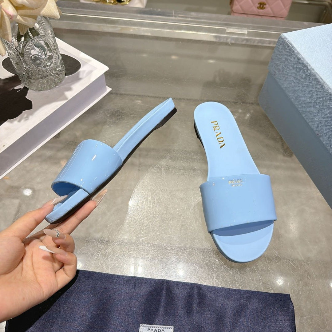 PRADA 26S LOGO EMBOSSED SLIDE SANDALS IN SKY BLUE PATENT CALFSKIN