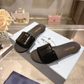 PRADA 26S LOGO EMBOSSED SLIDE SANDALS IN BLACK PATENT CALFSKIN