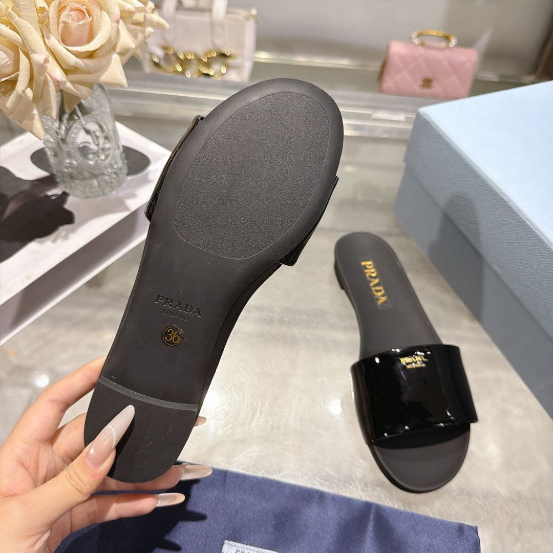 PRADA 26S LOGO EMBOSSED SLIDE SANDALS IN BLACK PATENT CALFSKIN