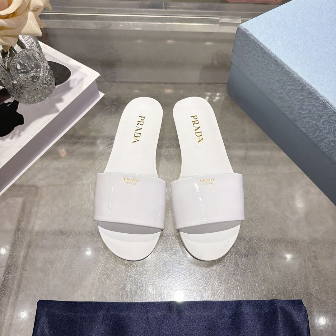 PRADA 26S LOGO EMBOSSED SLIDE SANDALS IN WHITE PATENT CALFSKIN