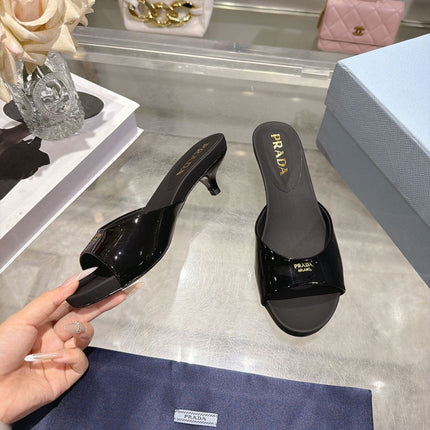 PRADA 26S LOGO EMBOSSED KITTEN HEEL MULES IN BLACK PATENT CALFSKIN