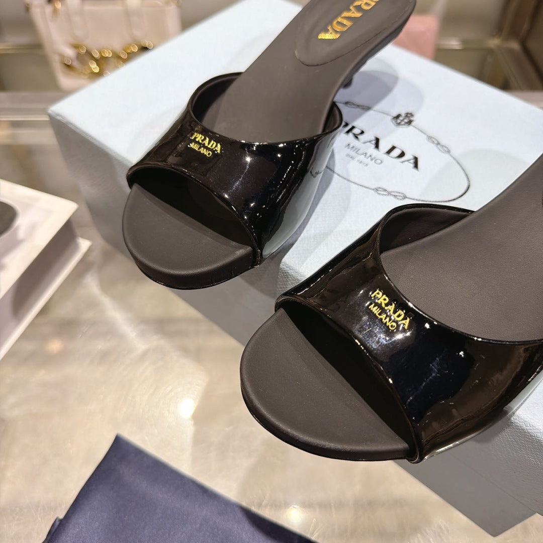 PRADA 26S LOGO EMBOSSED KITTEN HEEL MULES IN BLACK PATENT CALFSKIN