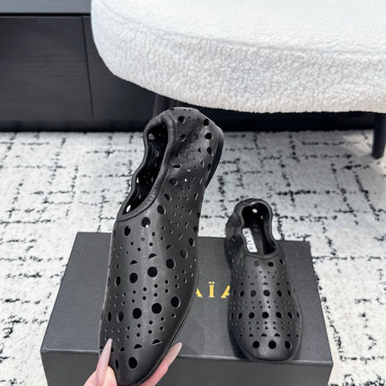 ALAIA 26S FLAT SLIP-ONS IN BLACK CALFSKIN WITH OPENWORK PATTERN